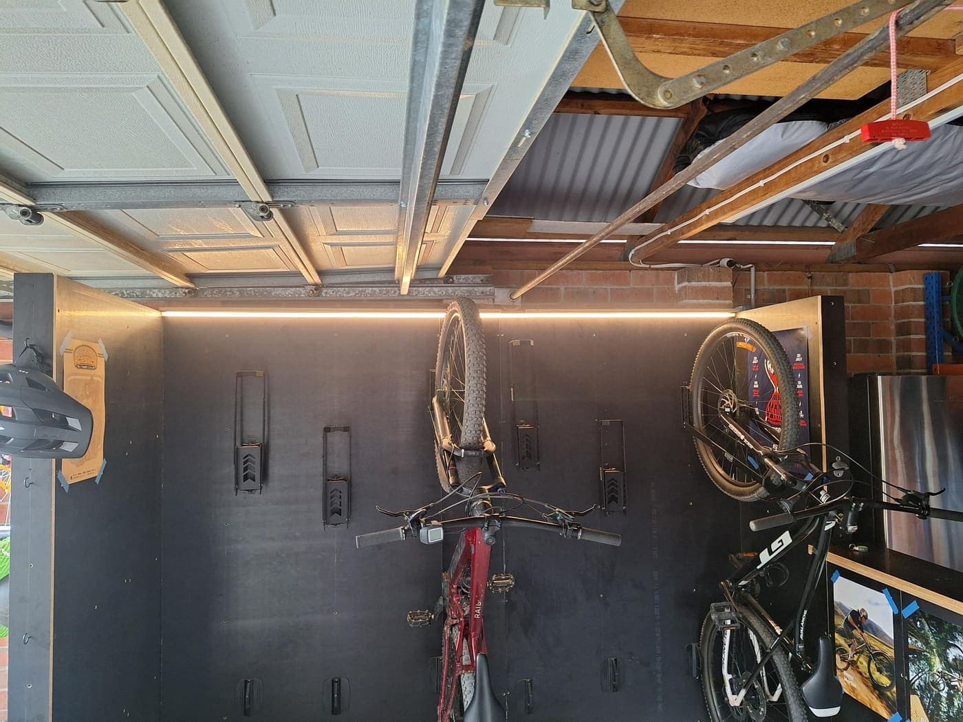 Garage fitted with warm LED strip lighting above a bike storage wall