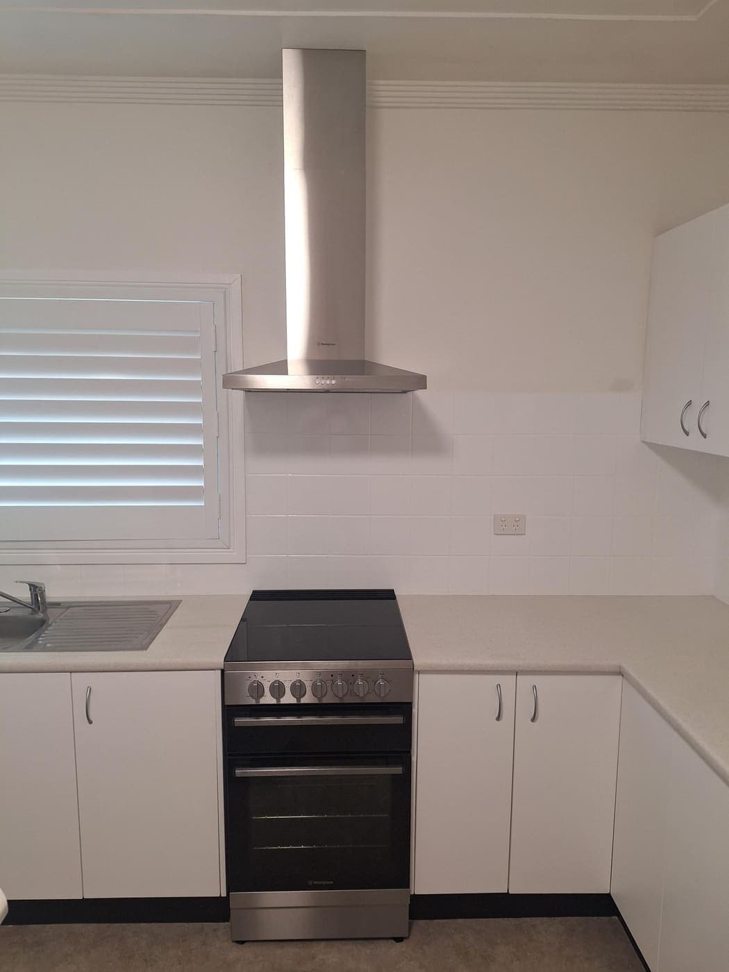 Stainless steel Westinghouse oven and canopy rangehood installed in a kitchen