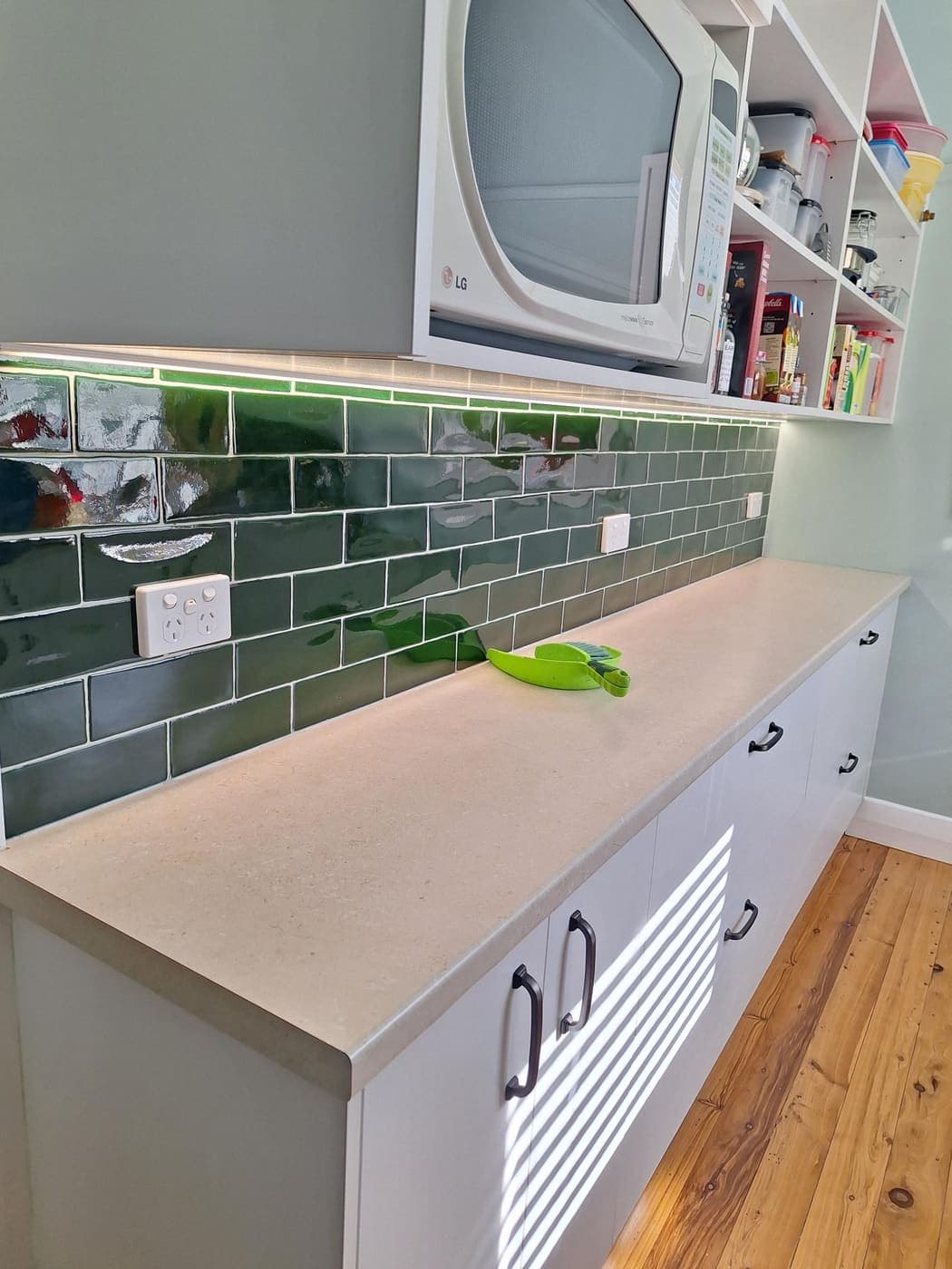 Laundry renovation with a green subway-tile splashback, power points and light switches