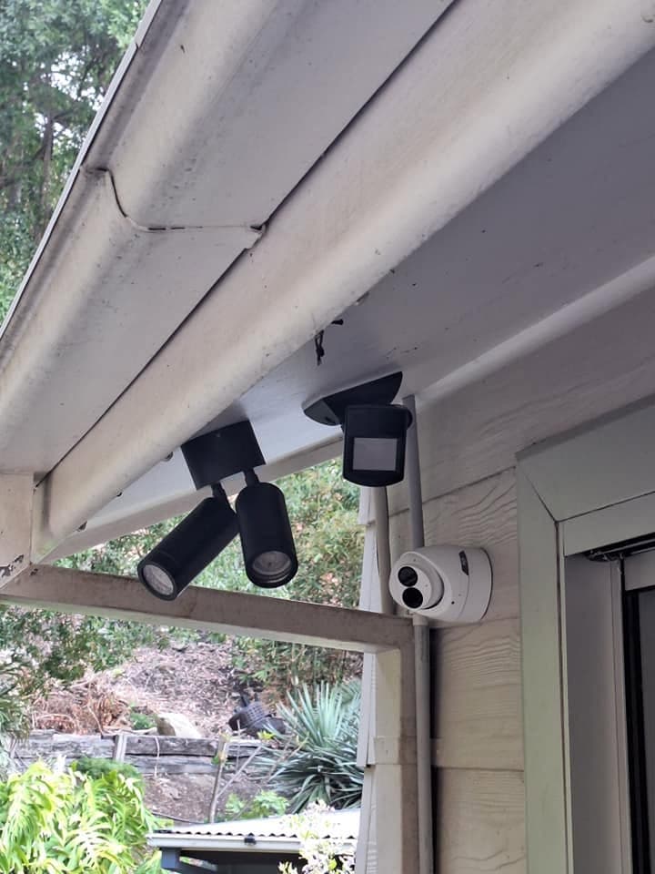 Security floodlights and a CCTV camera mounted on a house exterior