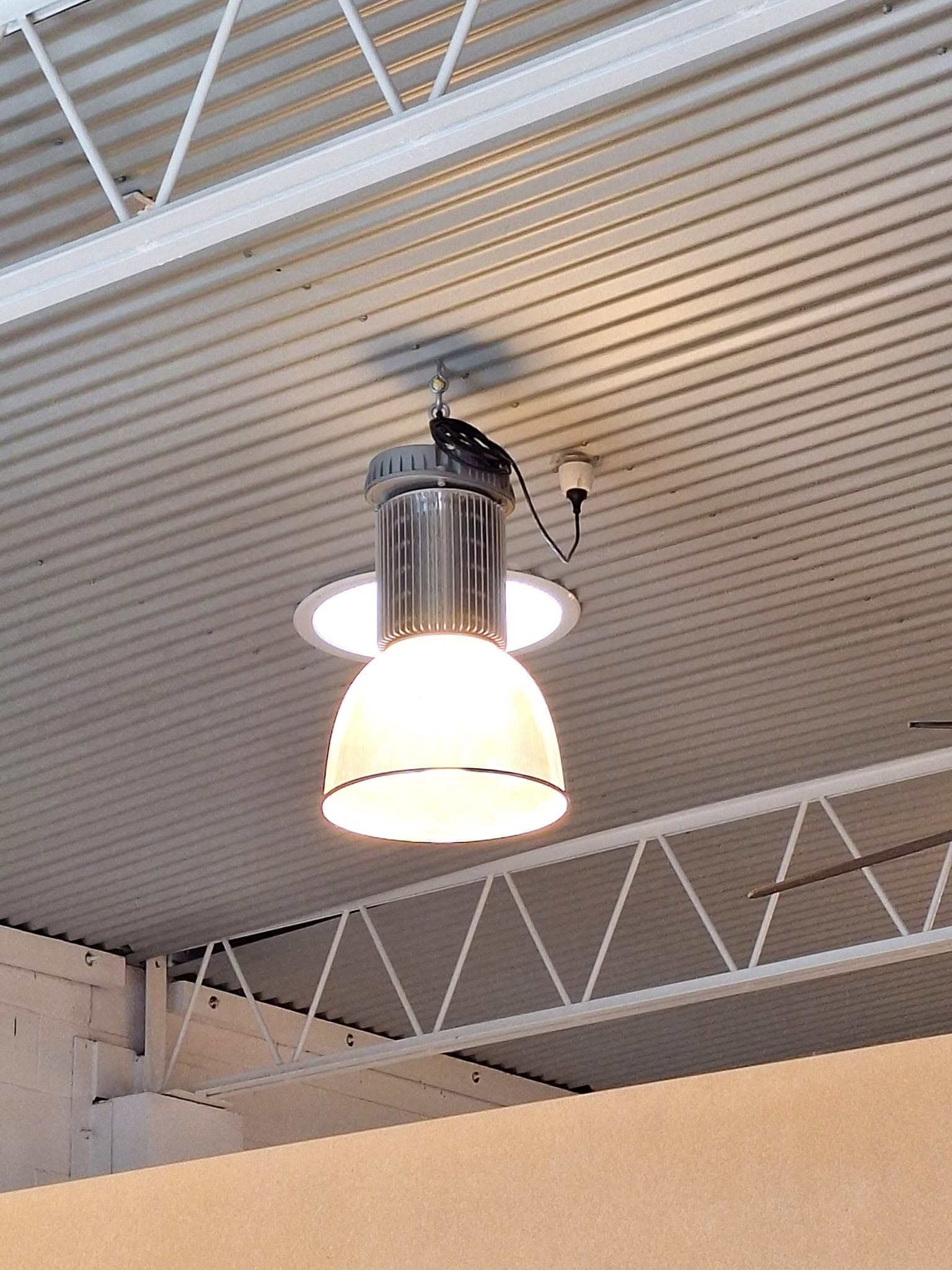 High-bay light fitting on the ceiling of a commercial warehouse
